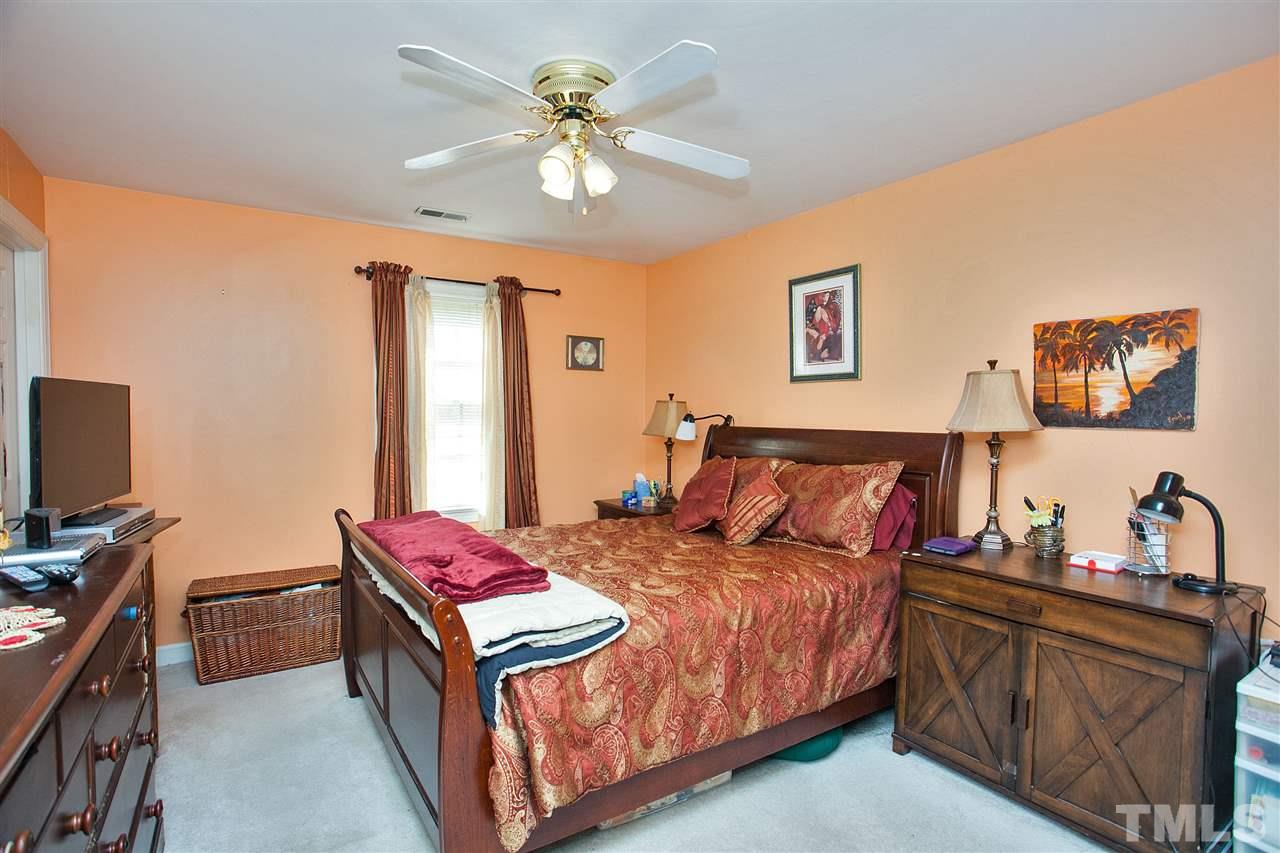 7021 Sandringham Court Raleigh, NC 27613 - Photo 14 of 25 a bed room with a bed window and a flat screen tv