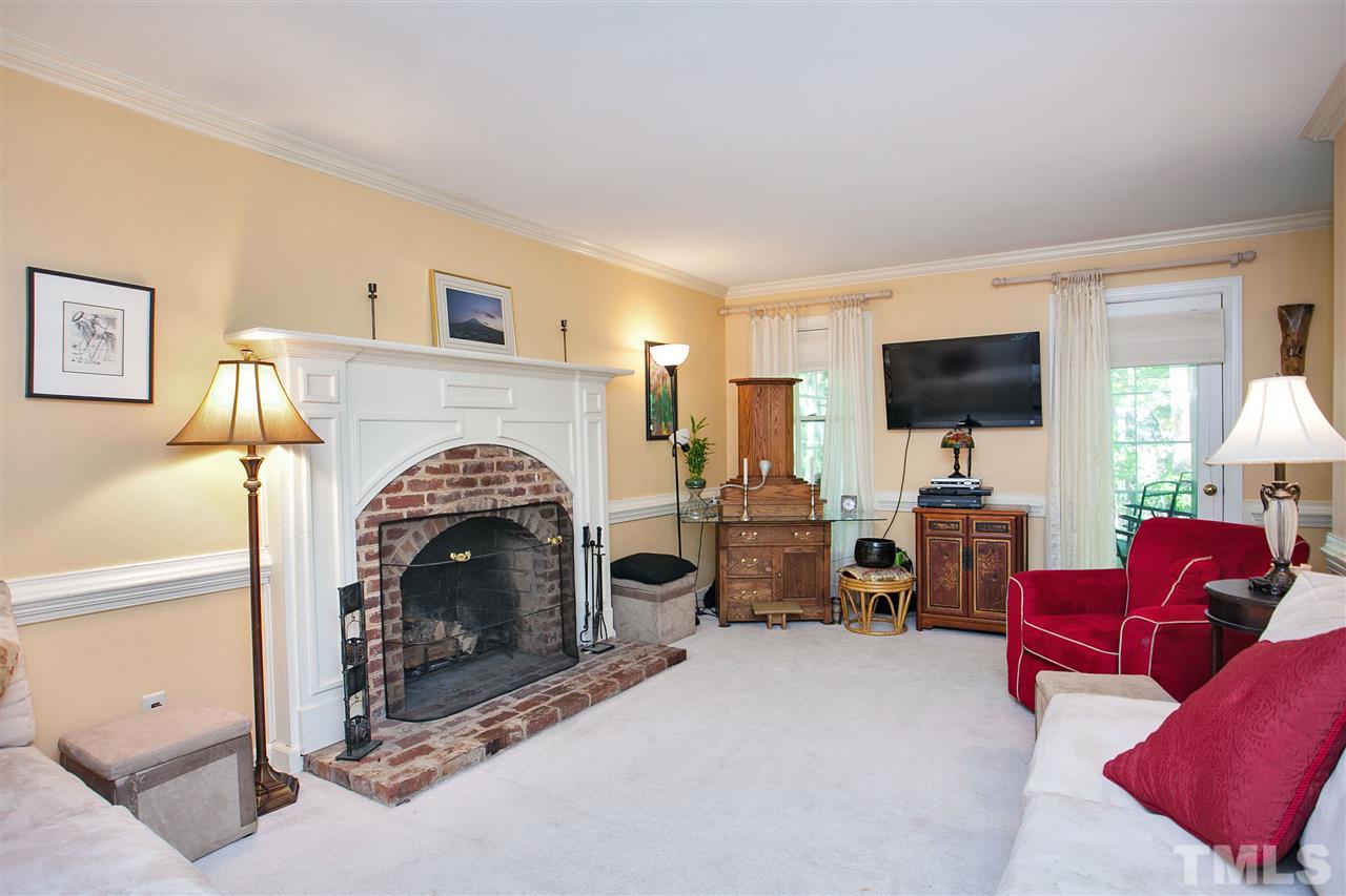 7021 Sandringham Court Raleigh, NC 27613 - Photo 3 of 25 a living room with furniture flat screen tv and a fireplace