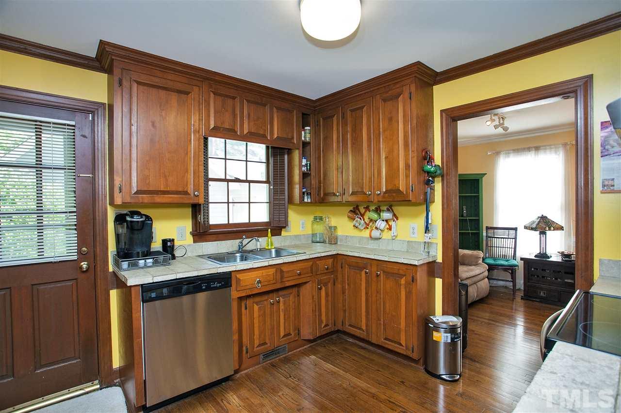 7021 Sandringham Court Raleigh, NC 27613 - Photo 7 of 25 a kitchen with stainless steel appliances granite countertop wooden cabinets a sink and dishwasher