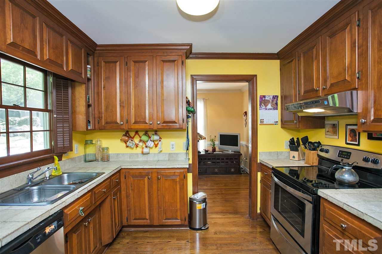 7021 Sandringham Court Raleigh, NC 27613 - Photo 8 of 25 a kitchen with stainless steel appliances granite countertop a sink a stove and a wooden cabinets