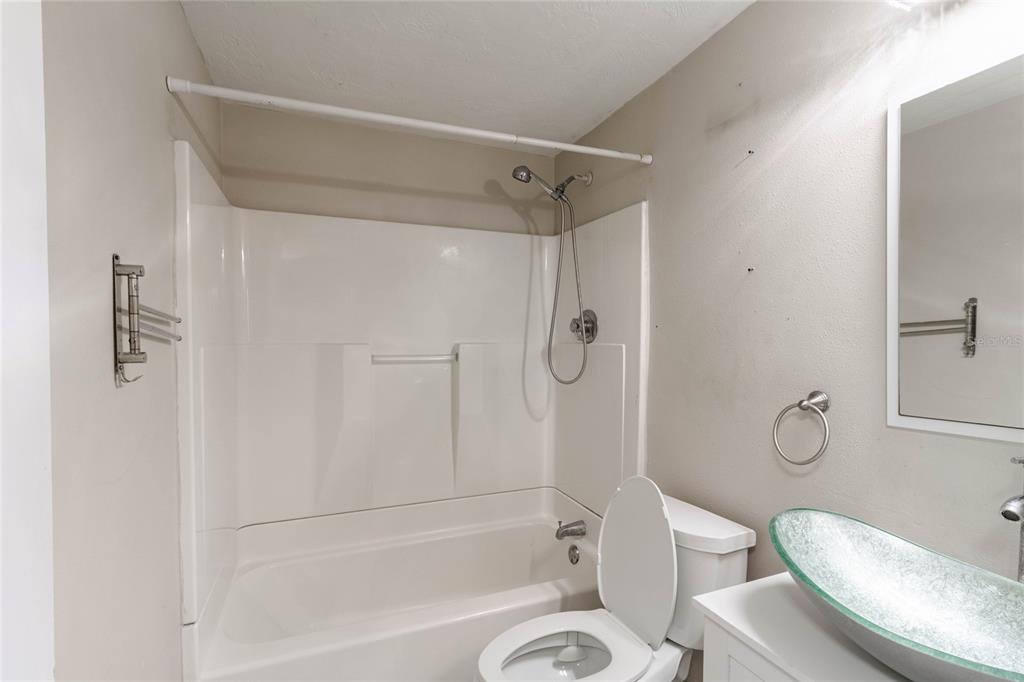 3402 Seffner Drive Holiday, FL 34691 - Photo 15 of 27 a bathroom with a granite countertop toilet a sink and a shower
