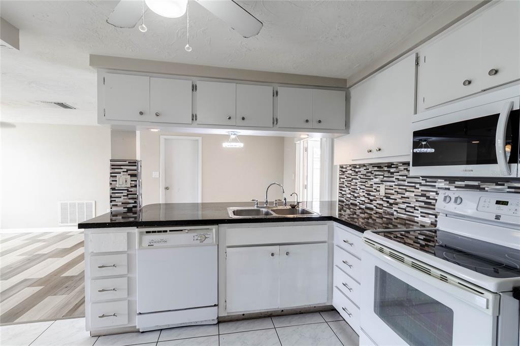 3402 Seffner Drive Holiday, FL 34691 - Photo 9 of 27 a kitchen with granite countertop white cabinets and appliances