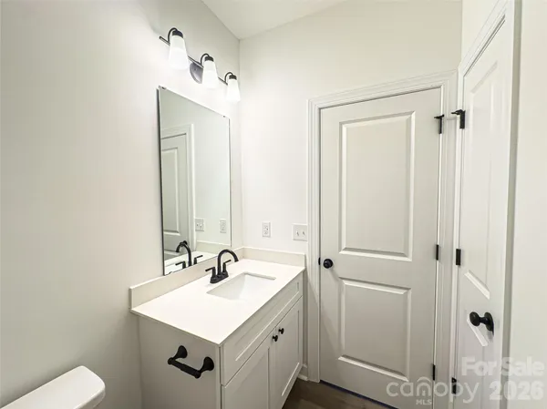 a bathroom with a sink a toilet and a mirror