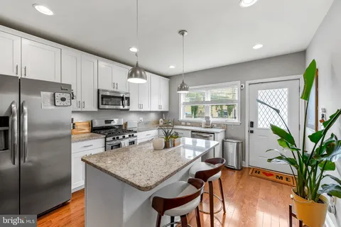 a kitchen with kitchen island a counter appliances a sink and cabinets