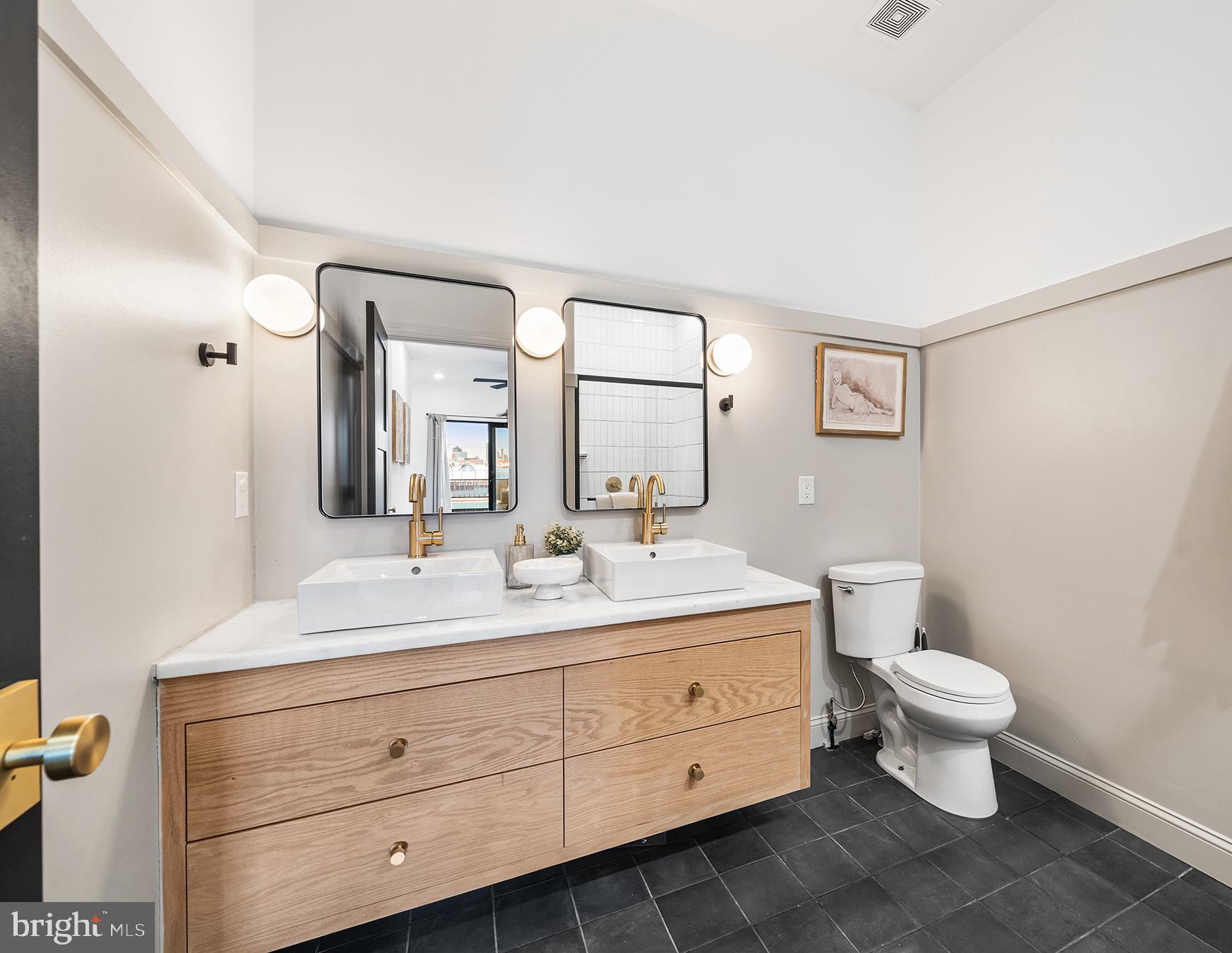1106 Watkins Street Philadelphia, PA 19148 - Photo 14 of 38 a bathroom with a double vanity sink toilet and mirror