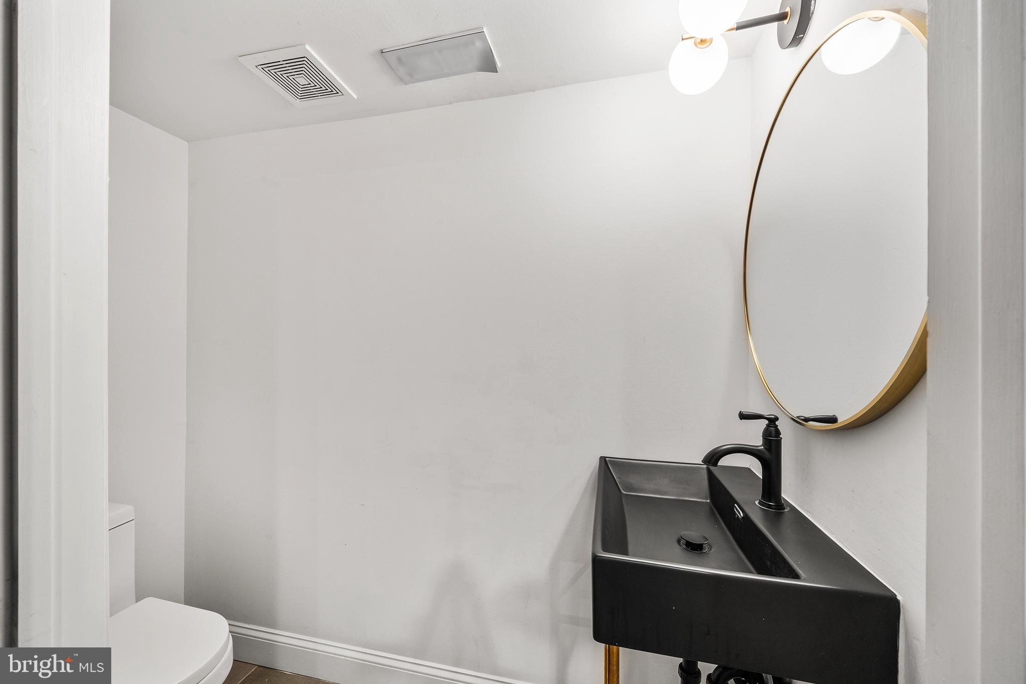 1106 Watkins Street Philadelphia, PA 19148 - Photo 30 of 38 a bathroom with a sink a toilet and a mirror