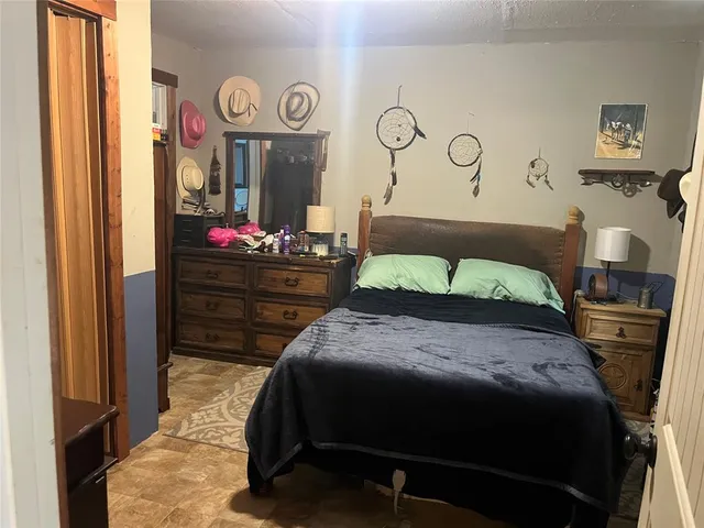 a bedroom with a bed and a table with wall painting