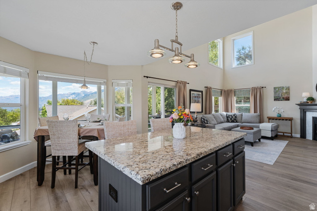 14883 Tooele Lane Draper, UT 84020 - Photo 18 of 49 Kitchen island featuring a granite countertop, dark cabinetry, and brushed nickel hardware