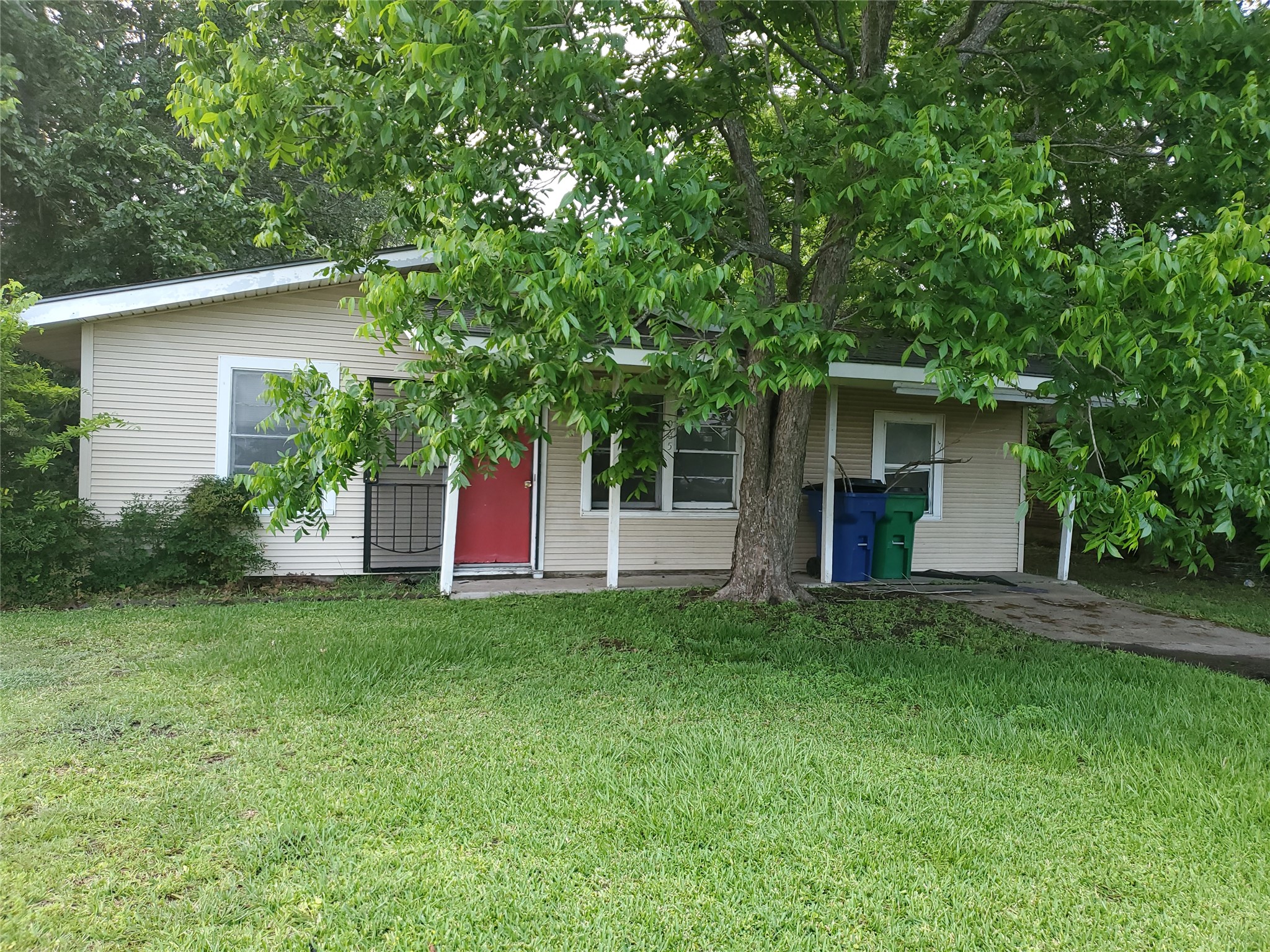 a view of a house with a yard and large tree