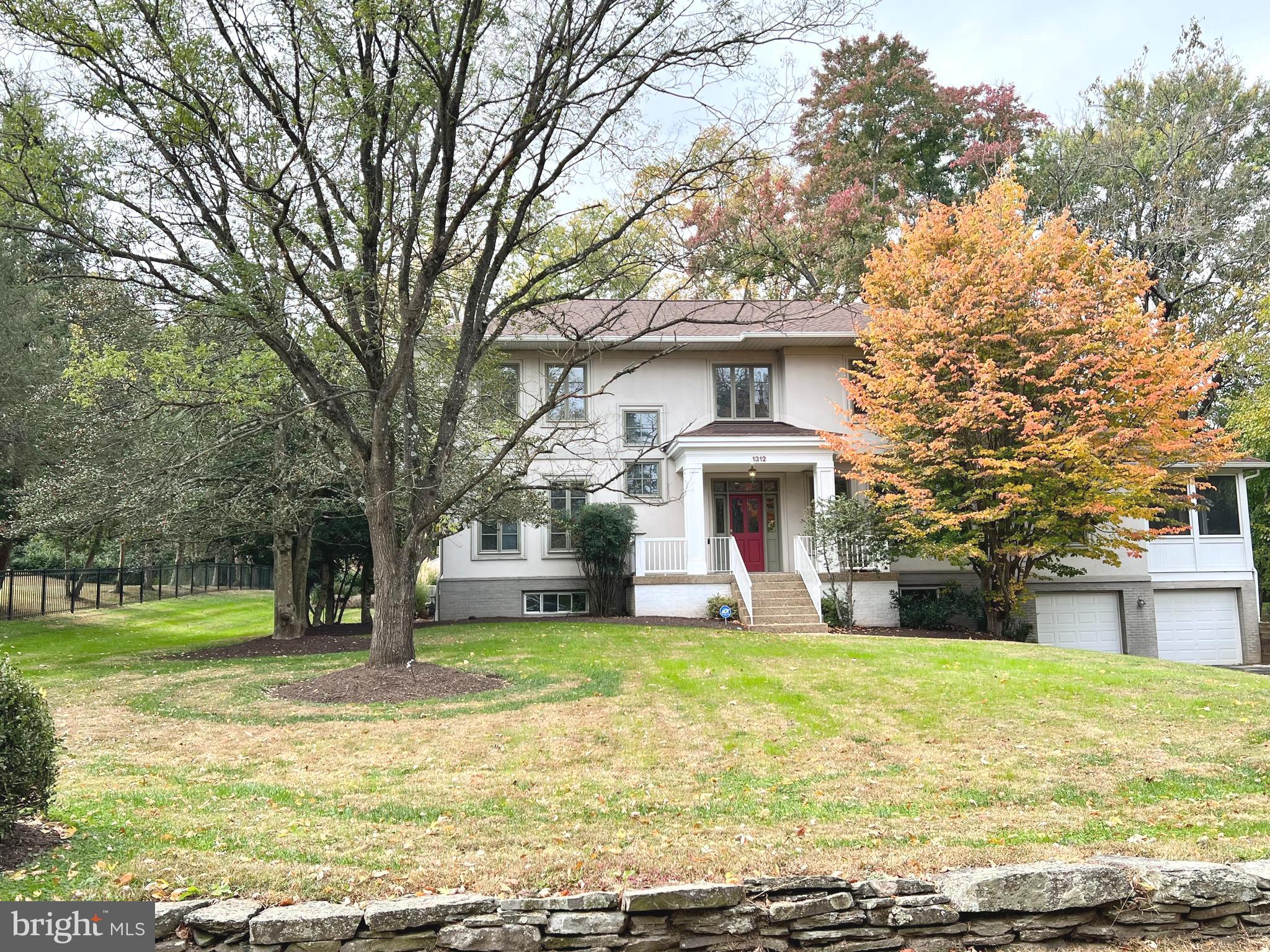 a view of a house with a yard and large trees