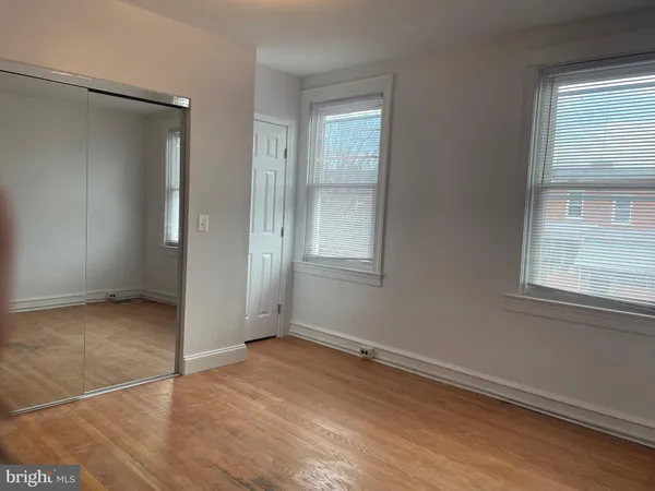 an empty room with wooden floor and a window