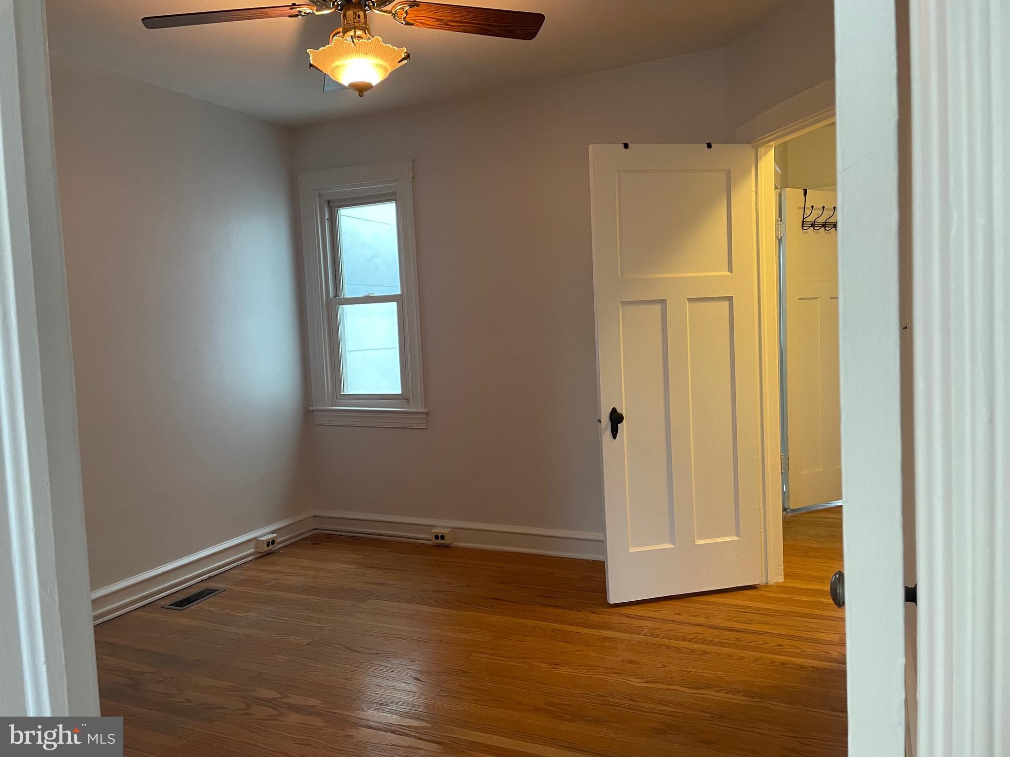 440 Elrino Street, Unit 2 Baltimore, MD 21224 - Photo 9 of 11 a view of an empty room with wooden floor and a window
