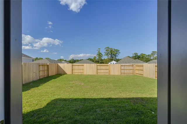 a view of a house with a yard and a large tree