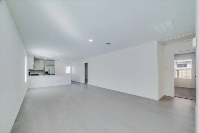a view of empty room with wooden floor