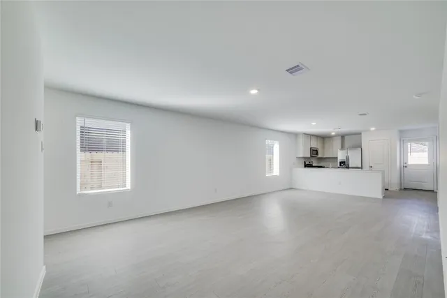 a view of empty room with window and wooden floor