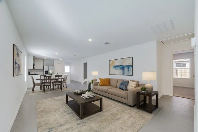 a living room with furniture and kitchen view