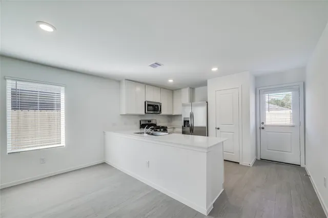 a kitchen with stainless steel appliances a sink stove and cabinets