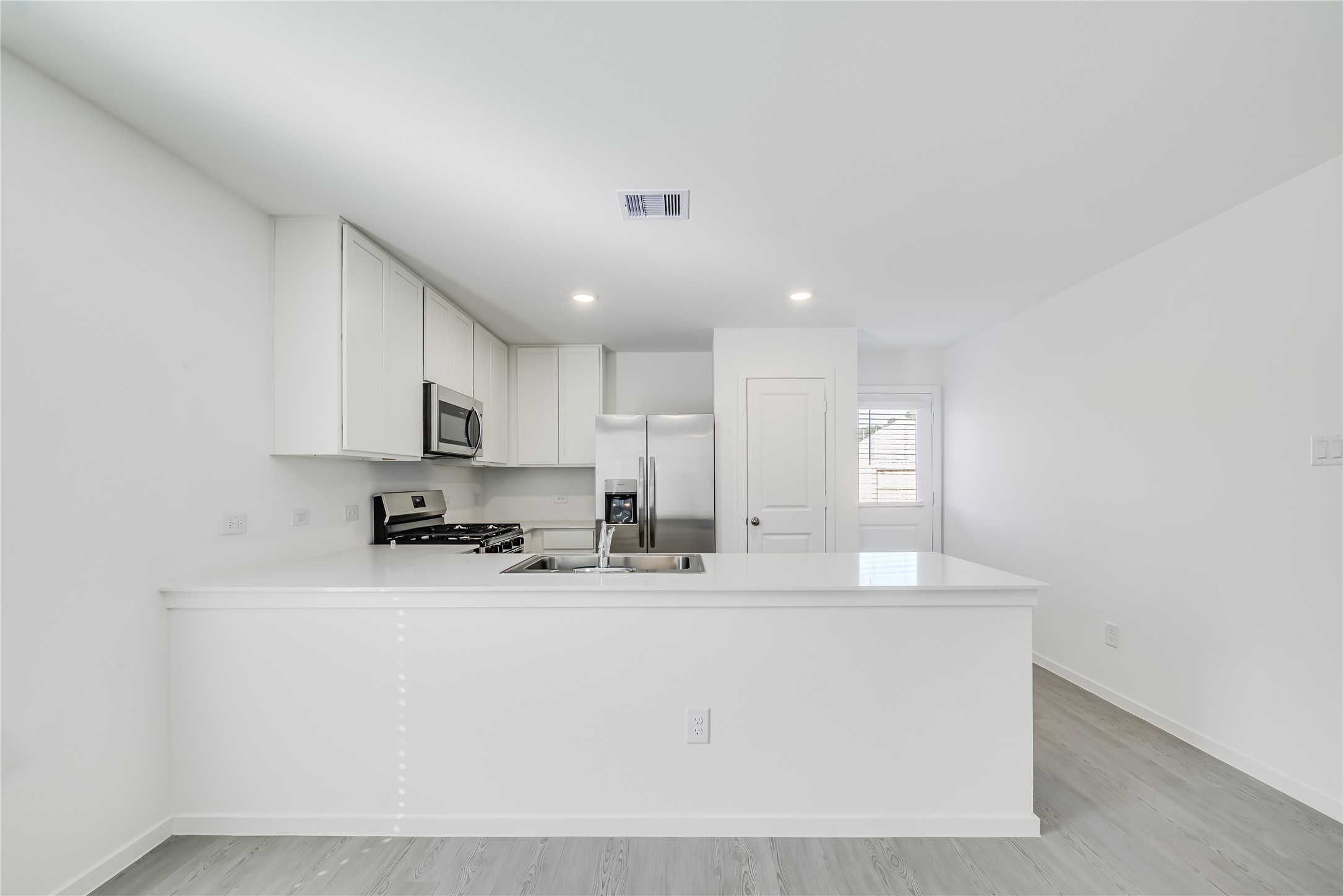 1754 West Stroker Road Crosby, TX 77532 - Photo 8 of 24 a kitchen with stainless steel appliances a sink a stove a microwave a refrigerator a center island and cabinets