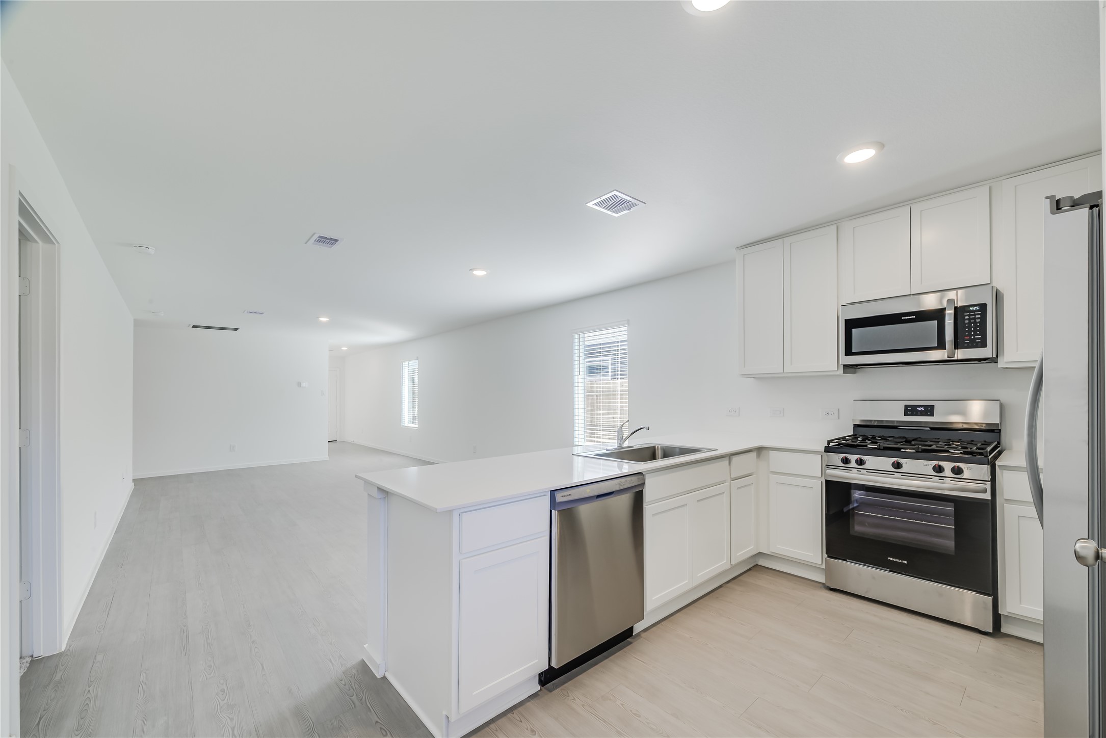 1754 West Stroker Road Crosby, TX 77532 - Photo 9 of 24 a kitchen with stainless steel appliances a sink stove and white cabinets