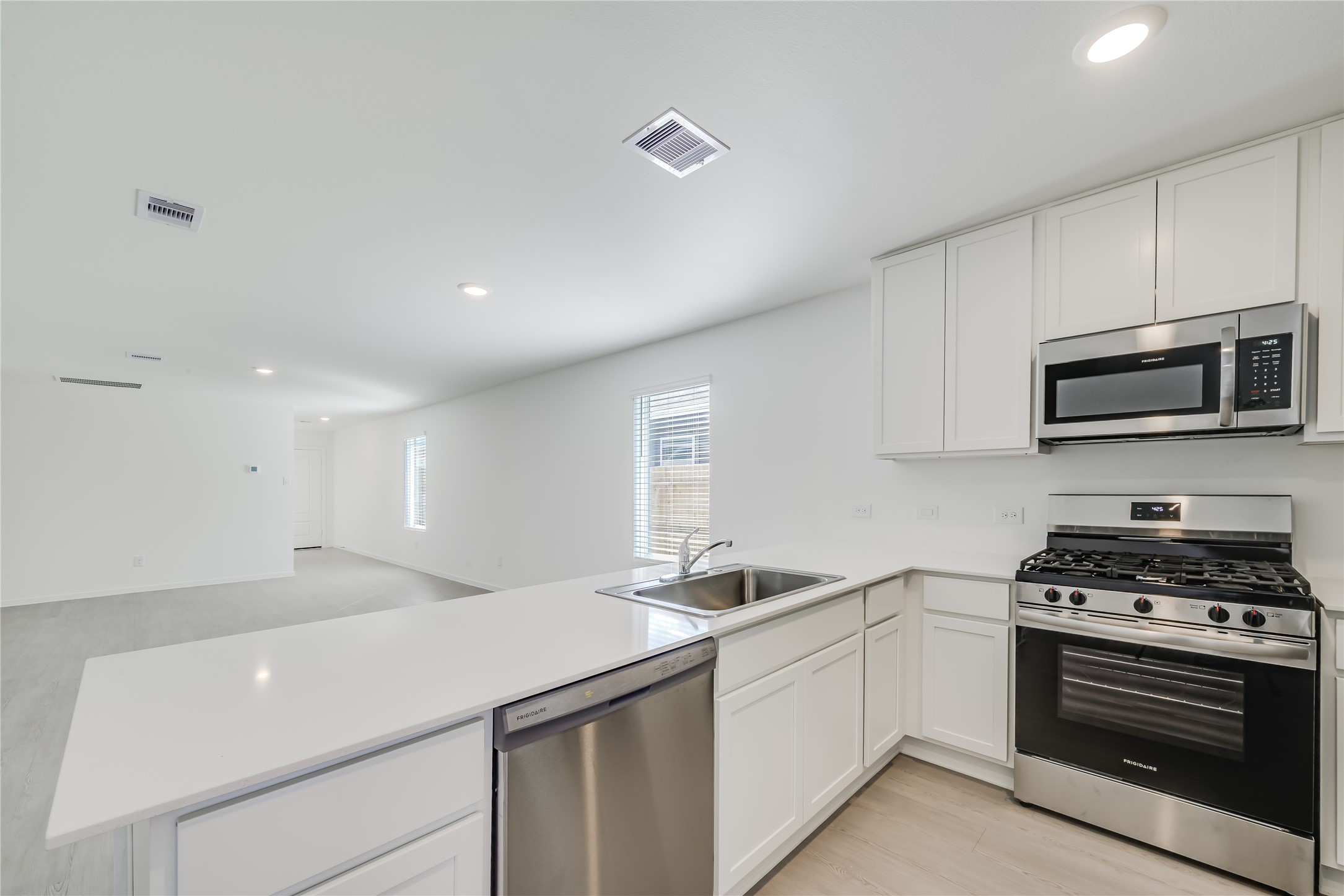 1754 West Stroker Road Crosby, TX 77532 - Photo 10 of 24 a kitchen with stainless steel appliances a sink dishwasher a stove and a microwave oven with cabinets