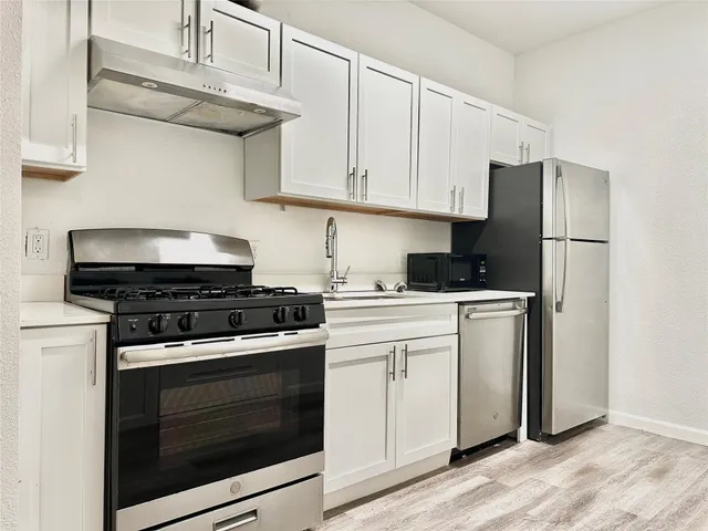 a kitchen with stainless steel appliances granite countertop a stove a refrigerator and cabinets