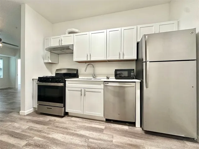 a kitchen with white cabinets and white appliances