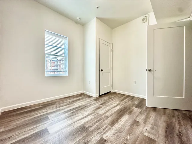 a view of an empty room with closet and a window