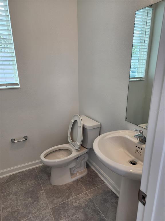 203 Bogey Drive Davenport, FL 33896 - Photo 6 of 41 a white toilet sitting next to a bathroom sink and vanity