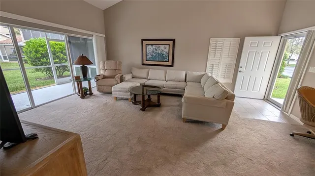 a living room with furniture and a floor to ceiling window