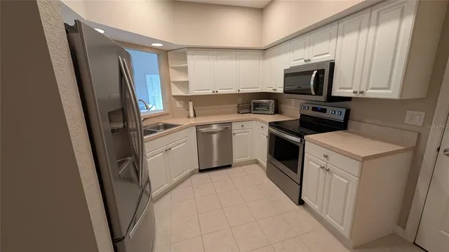 a kitchen with white cabinets stainless steel appliances and sink