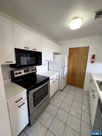 a kitchen with stainless steel appliances a stove a microwave and a refrigerator
