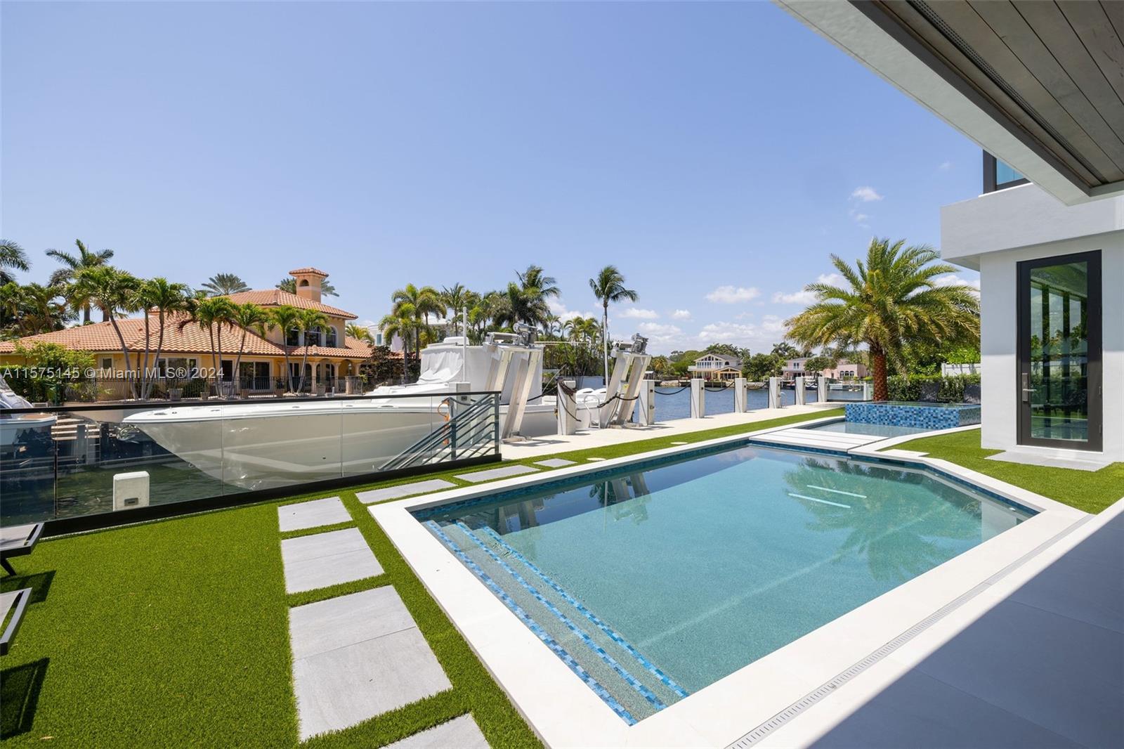 749 Bamboo Drive Boca Raton, FL 33432 - Photo 46 of 91 a view of a swimming pool with a lawn chairs and potted plants