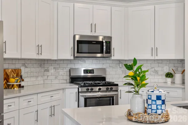 a kitchen with stainless steel appliances a white stove a microwave and cabinets