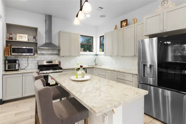 a kitchen with stainless steel appliances granite countertop a sink stove and refrigerator