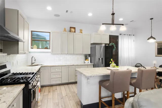 a kitchen with granite countertop a sink stove and refrigerator