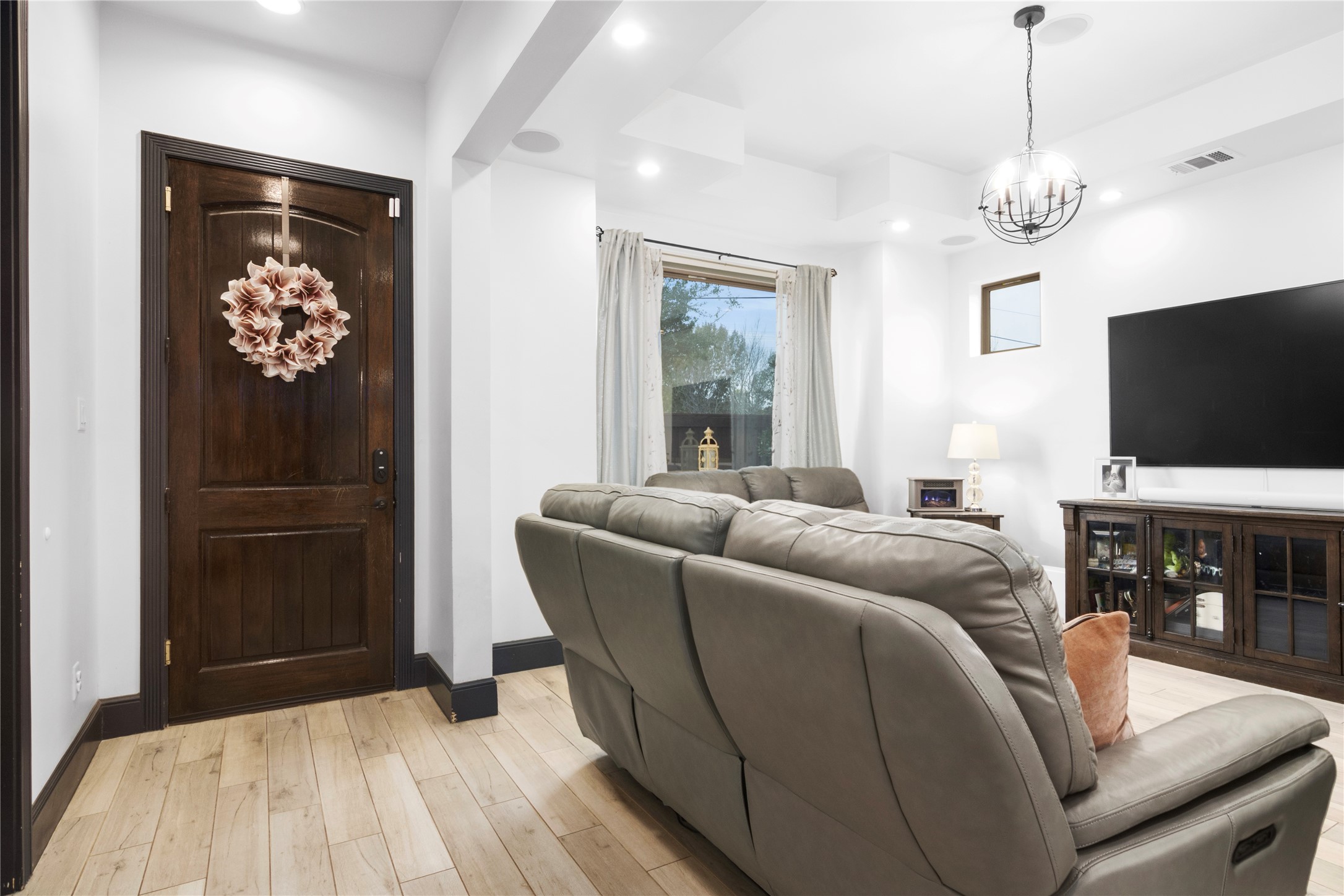 7341 Ave East Houston, TX 77011 - Photo 7 of 33 a living room with furniture a flat screen tv and a chandelier
