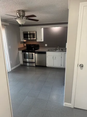 a kitchen with granite countertop a stove and cabinets