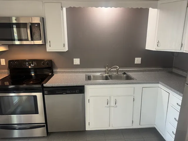 a kitchen with white cabinets and a stove
