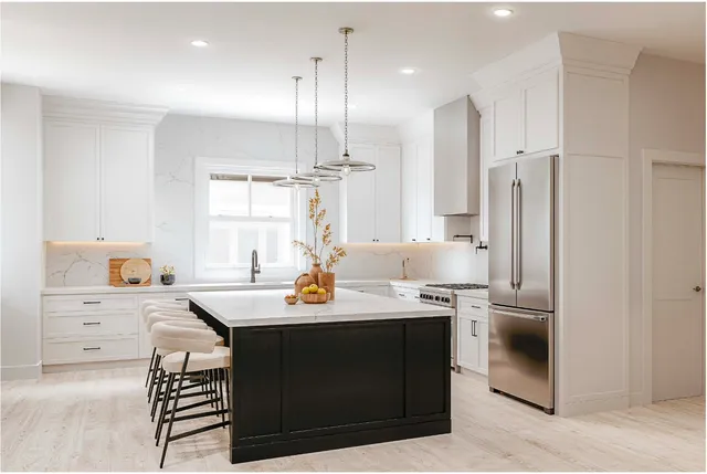 a kitchen with a sink a stove a refrigerator and white cabinets