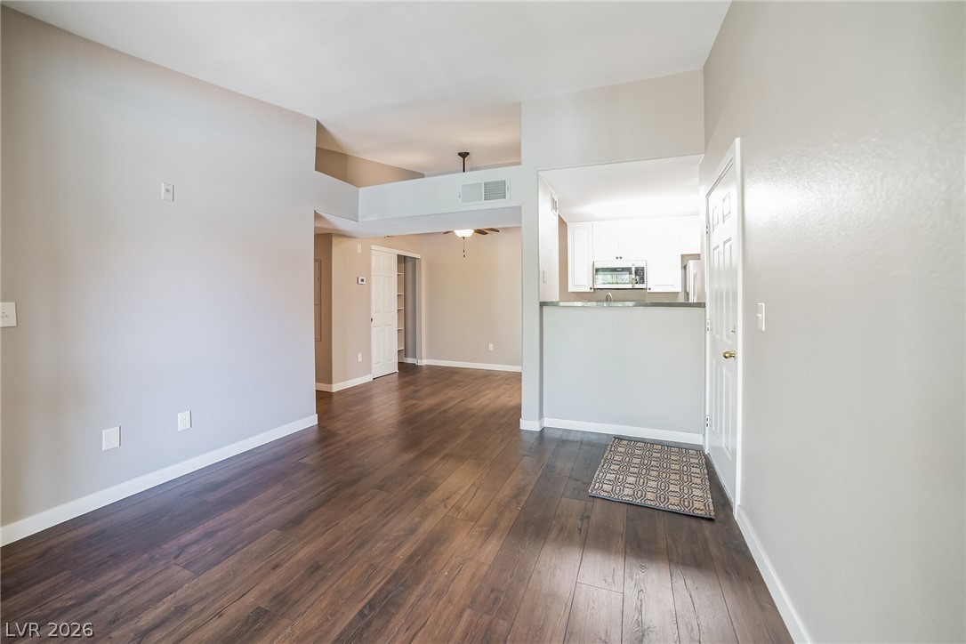 7885 West Flamingo Road, Unit 2041 Las Vegas, NV 89147 - Photo 8 of 14 Unfurnished living room featuring dark wood finished floors and baseboards