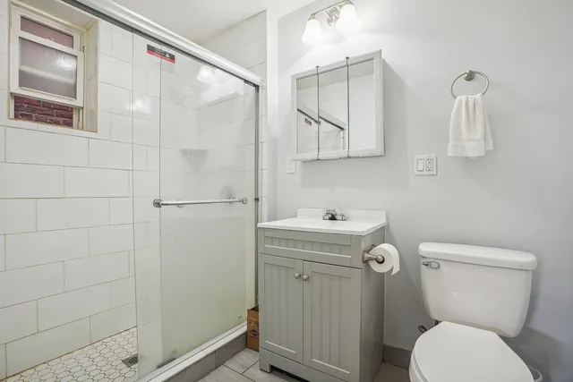 a bathroom with a sink a toilet and shower