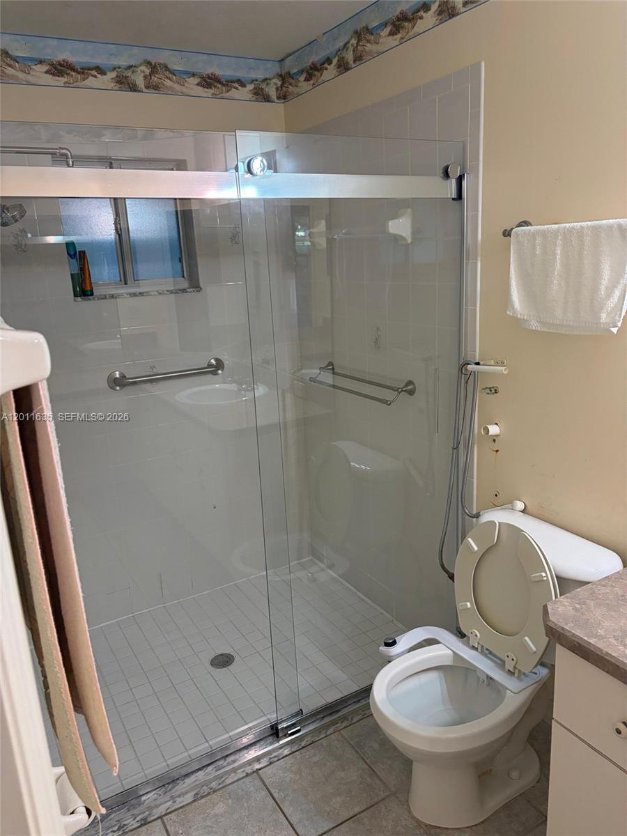 6064 Southwest 103rd Loop Ocala, FL 34476 - Photo 9 of 9 a bathroom with a granite countertop toilet a sink and shower