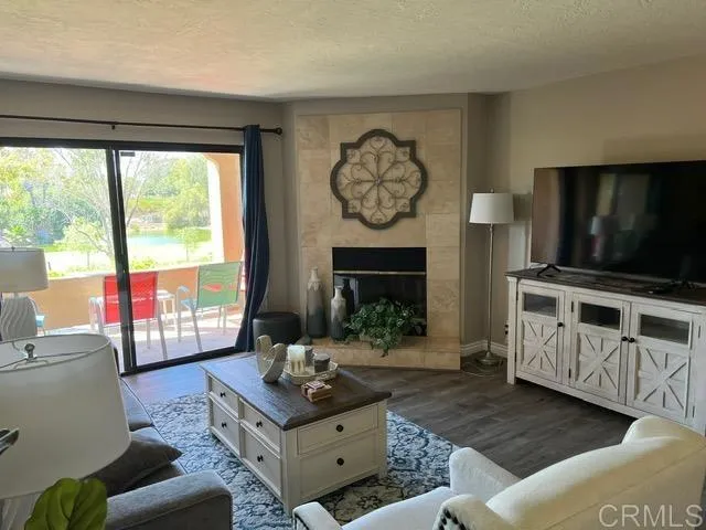 a living room with furniture a flat screen tv and a fireplace