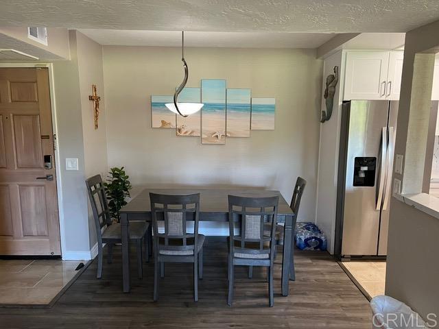 12260 Corte Sabio, Unit 5103 San Diego, CA 92128 - Photo 5 of 10 a view of a dining room with furniture and wooden floor