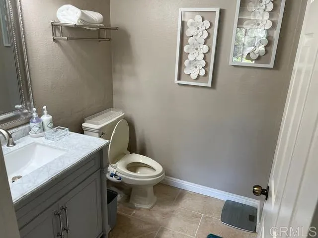 a bathroom with a granite countertop toilet and a sink