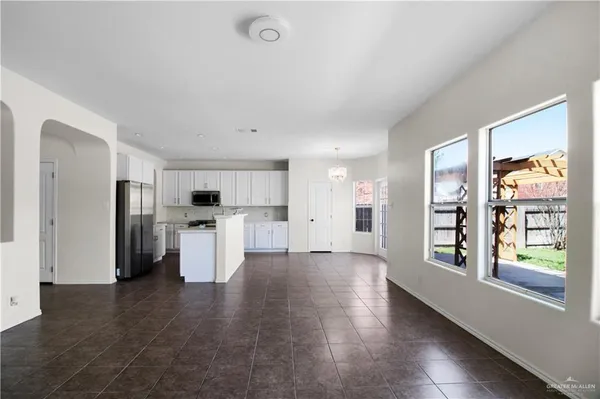 a view of a kitchen with refrigerator and wooden floor