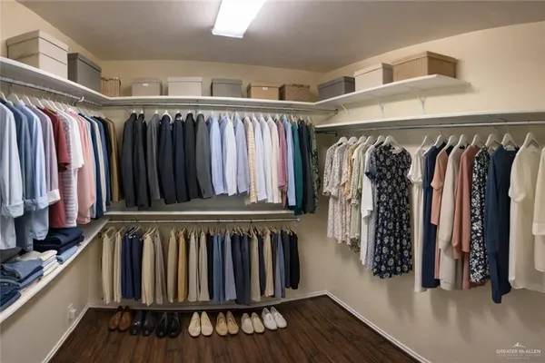 a view of walk in closet with clothes and shoes