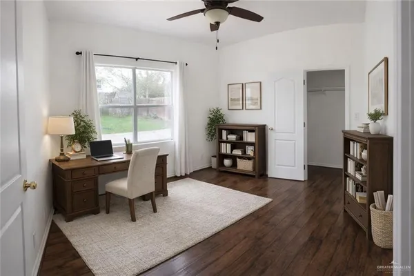 a view of a workspace with furniture and a window