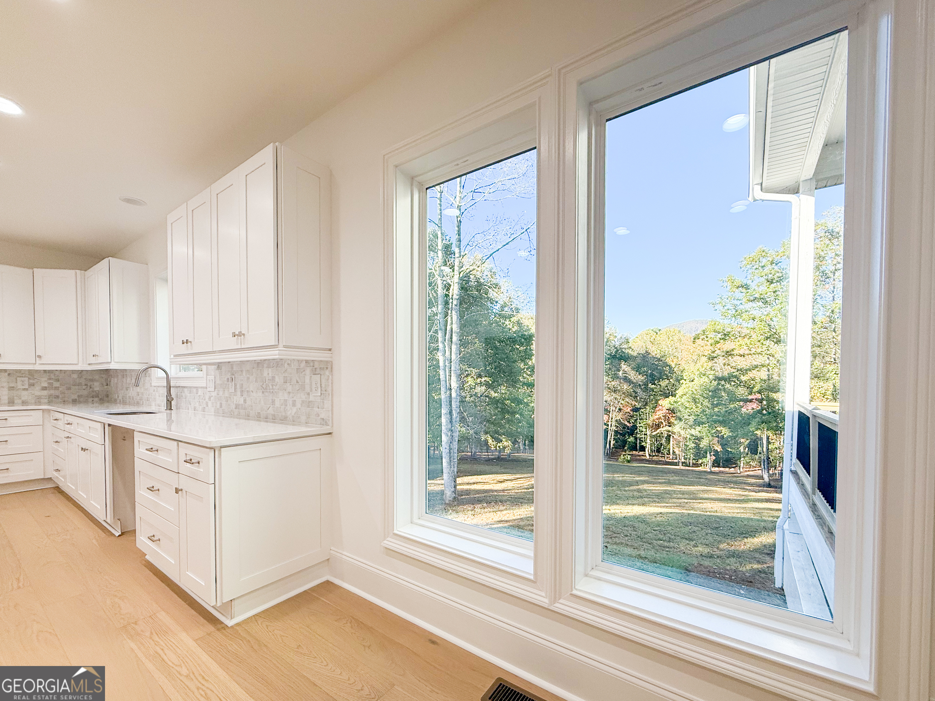 2125 Goat Neck Road Cleveland, GA 30528 - Photo 8 of 24 a kitchen with granite countertop a stove and white cabinets with wooden floor