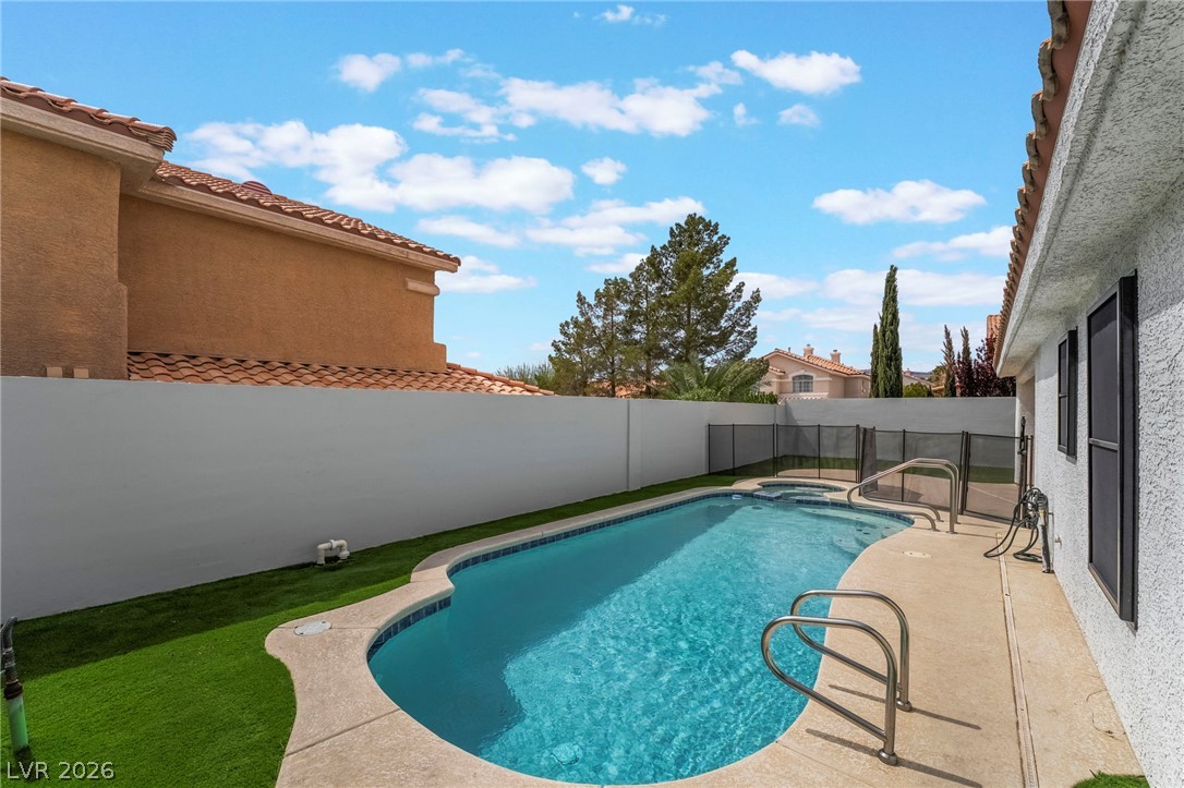 9171 West Viking Road Las Vegas, NV 89147 - Photo 42 of 43 An inviting in-ground pool awaits, perfectly complemented by a fenced spa area and low-maintenance turf.